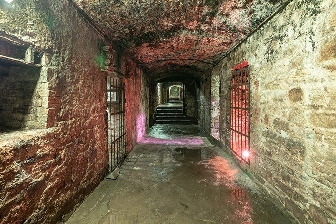 Narrow stone passage with barred gates in Edinburgh’s underground vaults