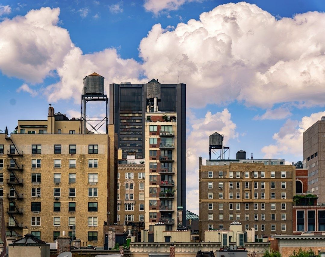 New York rooftops with elevated cylindrical water tanks beneath clouds